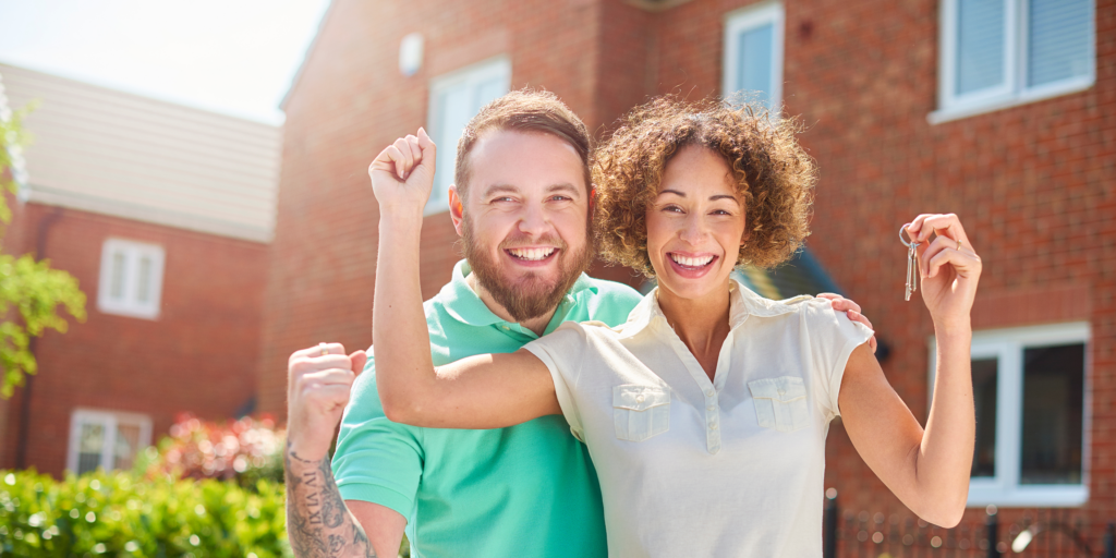 Couple holding a key to the newly bought home