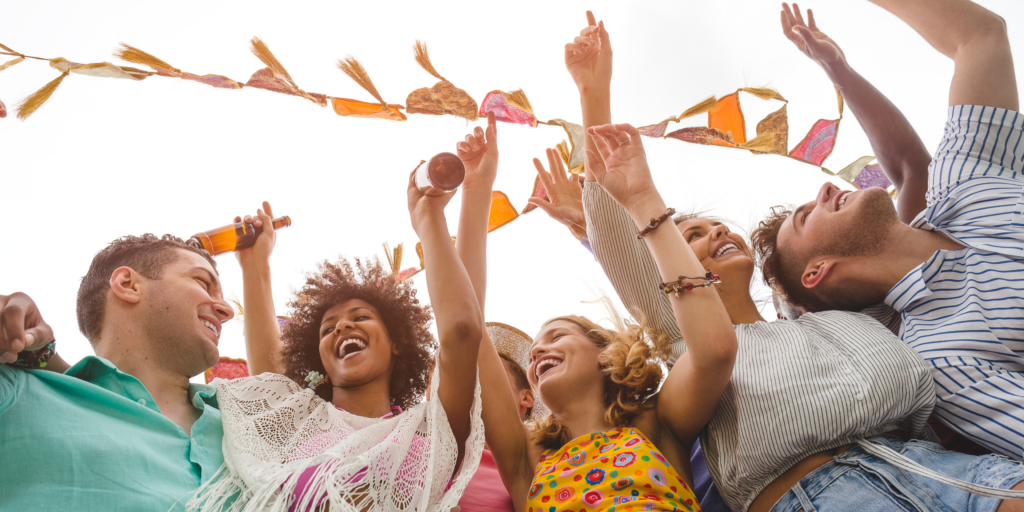 Group of friends enjoying festival concert with orange bandana in the background